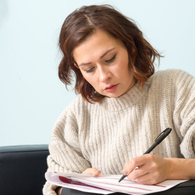 Woman reviewing complaints form as she fills it out